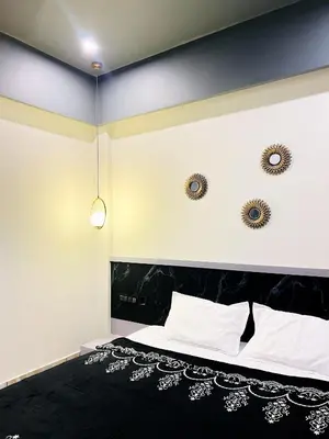 a bedroom with a black and white bed and two mirrors at oakden lakkidi villa vythiri villa wayanad in Vythiri