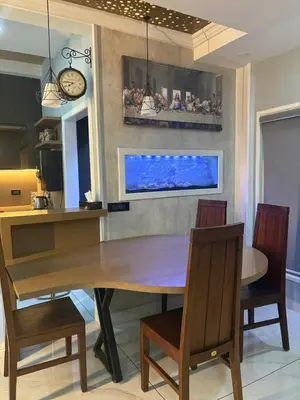 a dining room with a table and chairs and a clock at Evania Pool Suites in Nedumbassery