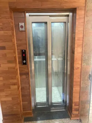 two glass elevators in a wooden wall with at Evania Pool Suites in Nedumbassery