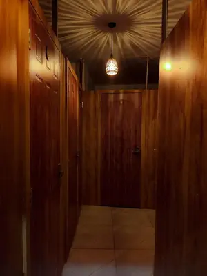 an empty hallway with wooden doors and a light fixture at Thekkini rooms and Dorms in Kozhikode