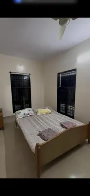 a bed in a room with two windows and a bedvisor at Offline Resort in Bengaluru, Karnataka