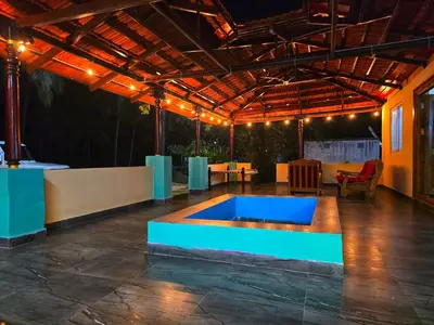a patio with a blue pool in the middle of it at Siruvani Forest Farmstay By Shivalaya Stays in Coimbatore