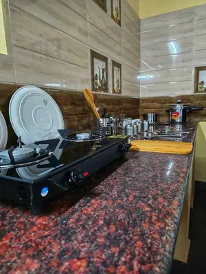 a kitchen with a counter top with a stove at Siruvani Forest Farmstay By Shivalaya Stays in Coimbatore