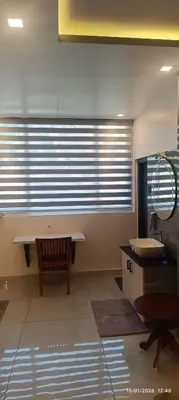 a room with a table and a chair and a window at blue Mount stay in Gūdalūr