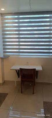 a table and a bench in front of a window at blue Mount stay in Gūdalūr