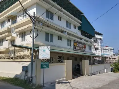 a white building with a sign in front of it at GG Residency in Palakkad