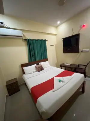 a bedroom with a large bed with a green curtain at G S Rooms Mysore in Mysore