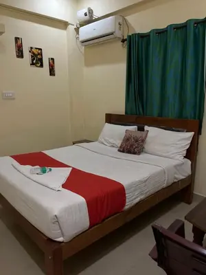 a bedroom with a large bed with a green curtain at G S Rooms Mysore in Mysore