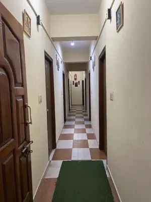 an empty hallway with a green rug on the floor at G S Rooms Mysore in Mysore