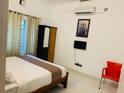 a bedroom with a bed and a red chair at Ocean pearl homestay-Manjeri in Malappuram