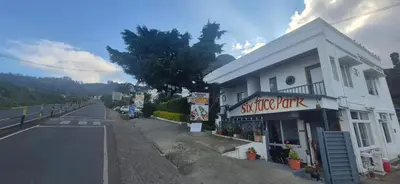 an empty street next to a white building at IndivaStays - Sixface Park in Ooty