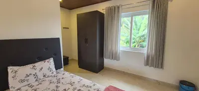 a bedroom with a bed and a window at IndivaStays - Sixface Park in Ooty
