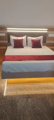 a bed with red pillows on it in a room at Thendral Stay Marayoor in Marayoor