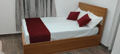 a bedroom with a bed with red and white pillows at Thendral Stay Marayoor in Marayoor