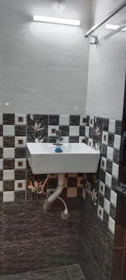 a sink in a bathroom with a tiled wall at Thendral Stay Marayoor in Marayoor