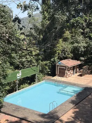 a swimming pool with a gazebo next to at Aditi By Greenleaves Resort Vythiri in Vythiri