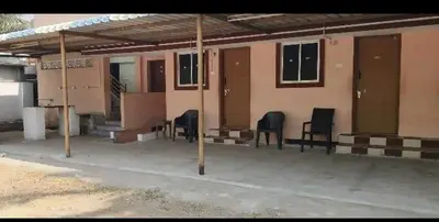 a group of chairs sitting outside of a building at Om Cottage in Palani