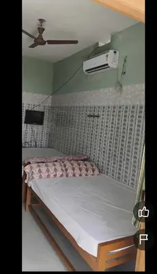 a bed in a bedroom with a ceiling fan at Om Cottage in Palani