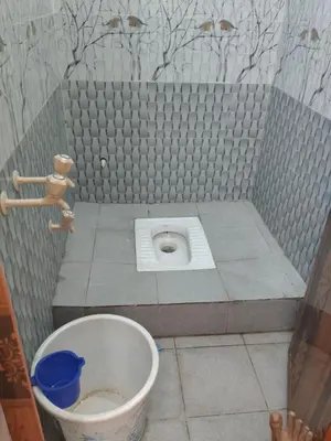 a small bathroom with a toilet in the floor at Om Cottage in Palani