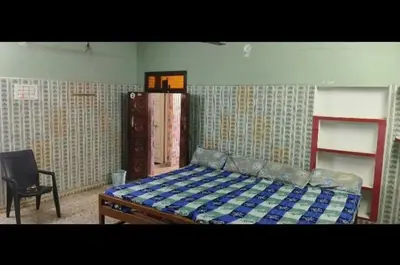 a bedroom with a bed and a chair in it at Om Cottage in Palani