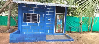 a blue building with a window and a door at Lavi's Homestay in Hārohalli