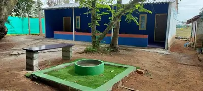 a building with a barrel and a bench and a house at Lavi's Homestay in Hārohalli