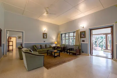 a living room with a couch and a table at amã Stays & Trails - Woshully Bungalow, Coorg in Gonikoppal