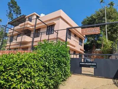 a building with a sign in front of it at Elnido Holiday Home in Meppādi