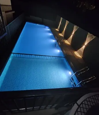 a swimming pool with blue lights in a room at Elnido Holiday Home in Meppādi