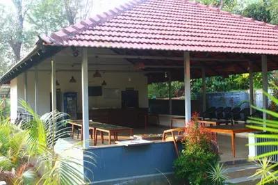 a pavilion with tables and chairs on a patio at Aranya Cottage Coorg in Suntikoppa