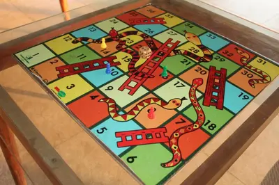 a game of monopoly on a glass table at Aranya Cottage Coorg in Suntikoppa