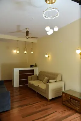 a living room with a couch and a fireplace at Nirantara Luxury Service Apartment in Gonikoppal