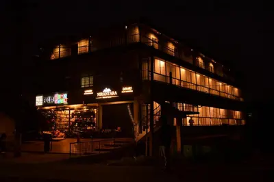 a building lit up at night with lights at Nirantara Luxury Service Apartment in Gonikoppal