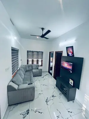 a living room with a couch and a flat screen tv at Stay loop in Cherambādi