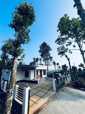 a white house with a tree in front of it at Stay loop in Cherambādi