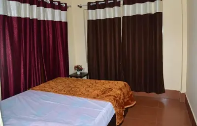 a bedroom with red curtains and a bed in a room at Joyful Homestay in Mysore