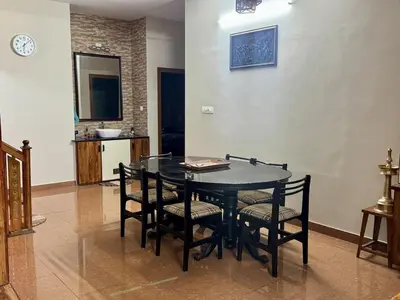 a dining room with a black table and chairs at Puranattukara- Serene Stay by the Rice Fields in Trichūr