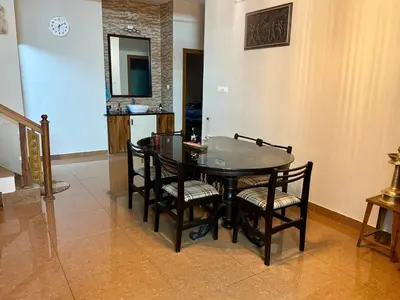 a dining room with a glass table and chairs at Puranattukara- Serene Stay by the Rice Fields in Trichūr