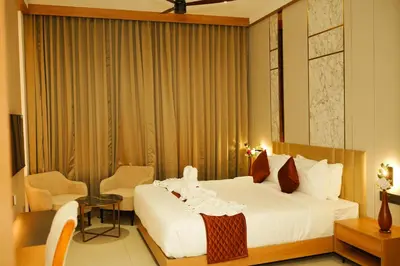 a hotel room with a bed and a table and chairs at Dwaraka INN