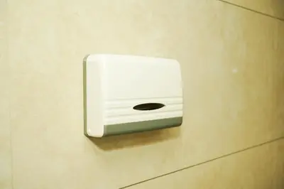 a white soap dispenser on a wall at Dwaraka INN