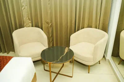 two chairs and a coffee table in a room at Dwaraka INN