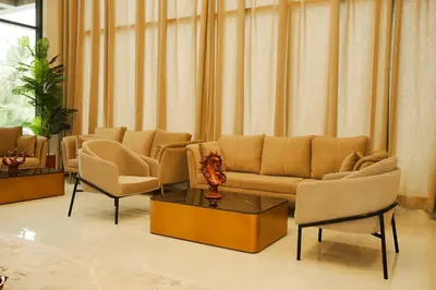 a living room with a couch and chairs and a table at Dwaraka INN