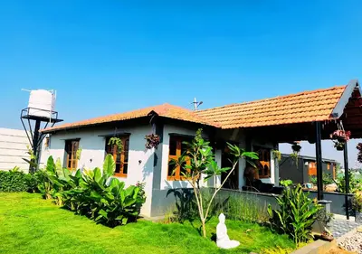a house with a green lawn in front of it at Sol Malai Retreat near MM Hills by Travent Mug