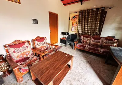 a living room with couches and a wooden table at Sol Malai Retreat near MM Hills by Travent Mug