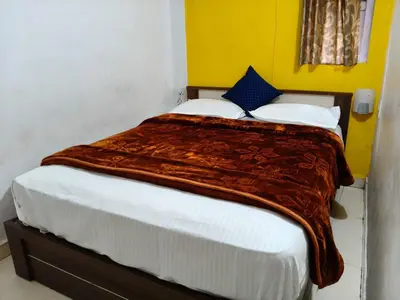 a bedroom with a large bed with a blanket on it at White House Resort in Ooty