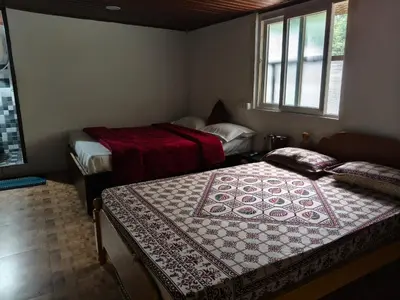 a room with two beds and a window at White House Resort in Ooty