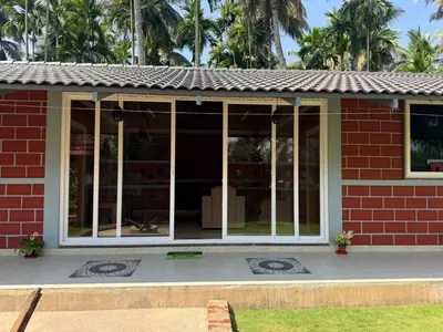 a red brick building with glass doors on it at Dhani Nature Stay in PÄndavapura