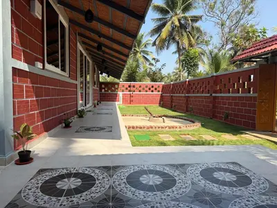 a courtyard of a building with a bench on the ground at Dhani Nature Stay in PÄndavapura