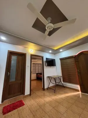 a living room with a ceiling fan and a door at Sawan house in Tāzhekkod