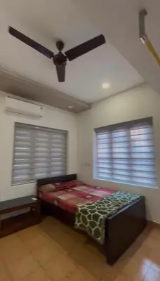a bedroom with a bed in a room with two windows at Sawan house in Tāzhekkod